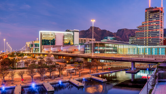 Cape Town city buildings illuminated after sunset, view across CTICC canal, South Africa