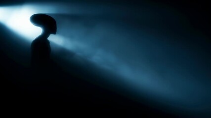 Alien silhouette in mysterious beam of light. UFO concept and extraterrestrial horror with dark blue glow.
