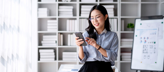 Accounting business concept, Accountant woman smiling and using smartphone to take a break for relaxation