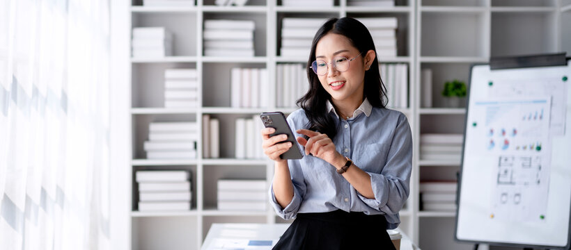 Accounting business concept, Accountant woman smiling and using smartphone to take a break for relaxation - Powered by Adobe