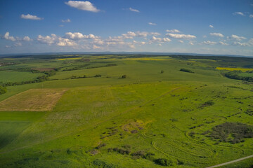 A drone view of agricultural green and yellow fields, panoramic landscape.