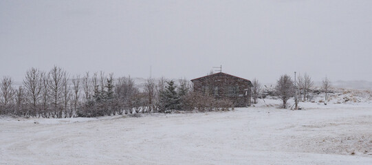 Snow falling on a small wooden house in iceland during winter