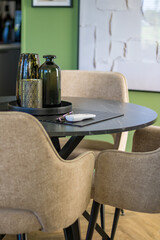 Soft chairs, table and vase in stylish dining room. High quality photo