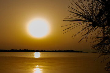 Beautiful sunrise on the beach above sea or ocean. Reflection of sun in the water. 