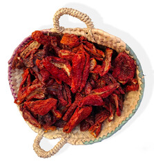 Sun dried tomatoes in a wicker basket at a vibrant farmers market in Spain during a sunny afternoon