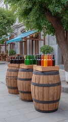 Craft beer barrel local concept. Three wooden barrels display colorful bottles in an outdoor setting, surrounded by greenery and architecture.