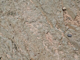 Close-up of cracked and textured rocks with small pebbles