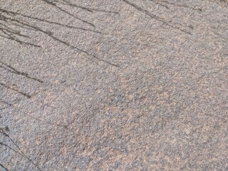 Textured surface of rough stone with natural patterns and tiny embedded particles, background...