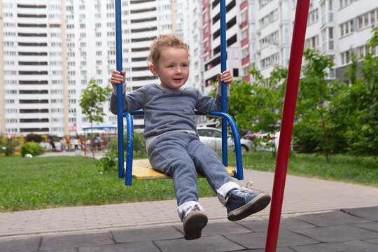 Curly child for swing in the playground near the house