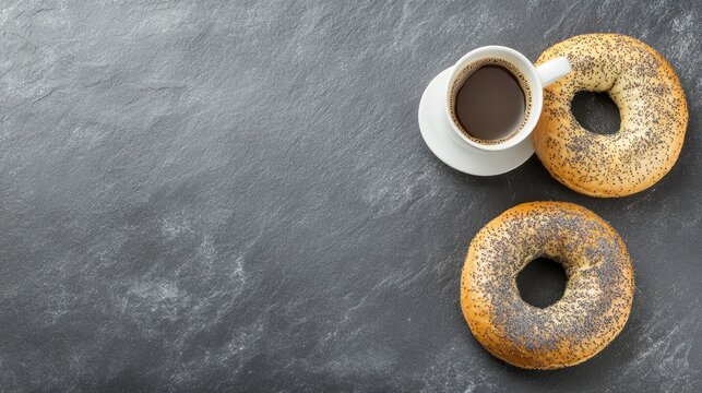 Poppy seed bagels and coffee on dark stone