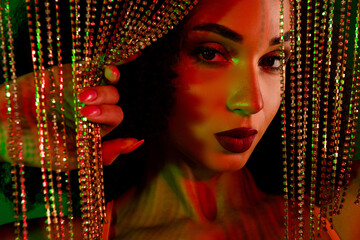 Stylish woman posing with glamourous jewelry under dramatic green gradient lighting in an artistic...
