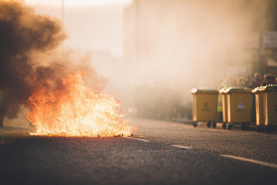 chaotic scene of crowd setting fire to garbage bins in ballymena flames rising high expressions of excitement and