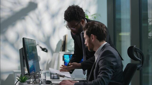 Annoyed African American leader dissatisfied boss scolding arguing Caucasian office worker businessman wrong failed project computer business men males problem conflict director swear employee mistake