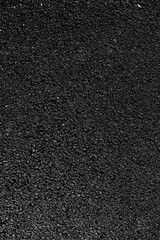 Texture of freshly laid black asphalt with coarse gravel surface variety and uniform finish