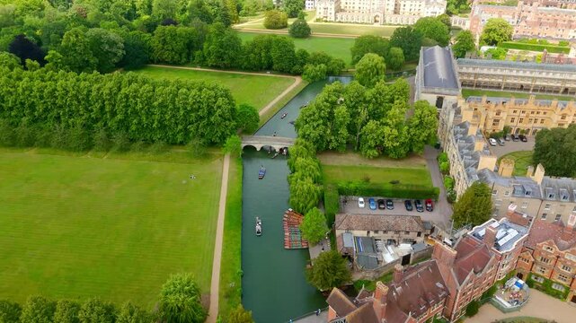 Aerial view of punts sailing on the River Cam with Cambridge University buildings and green spaces in the background