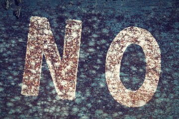 Old inscription NO on a blue background. Fragment of old dirty sign.