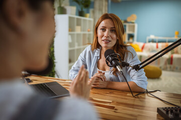 under the shoulder view of female host record podcast at home studio