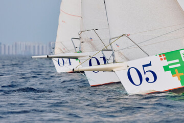 Sailing regatta in the Gulf of Finland at sunset, few sailing yachts competing in a race, splashing...