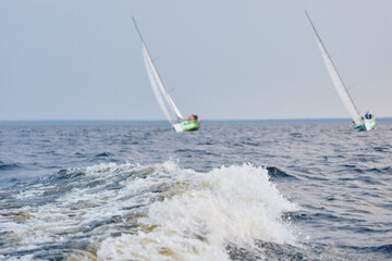 Sailing regatta in the Gulf of Finland at sunset, sailing yacht competing in a race, splashing...