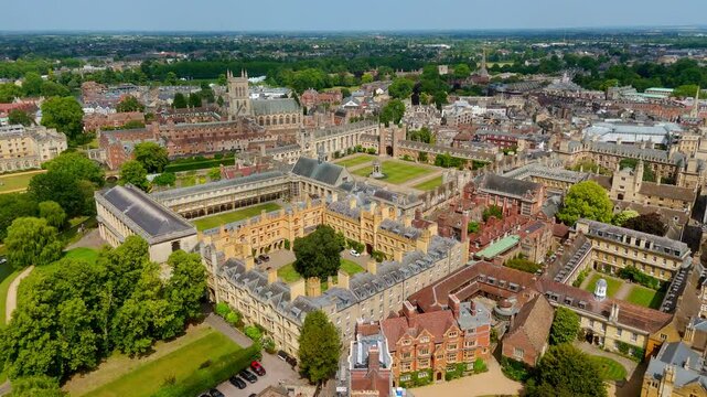 Cambridge colleges, courtyards and green meadows bathed in sunlight during a summer day, aerial view of Cambridge city center, UK