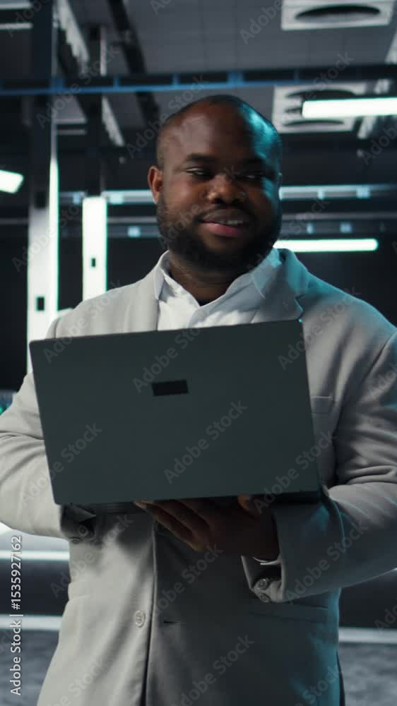 Poster vertical video data center engineer coding on laptop, doing software updates for mainframes. server 