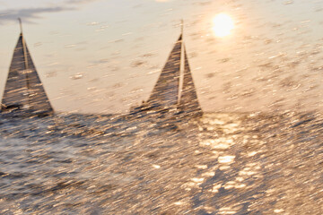 Sailing regatta in the Gulf of Finland at sunset, two sailing yachts competing in a race, splashing...