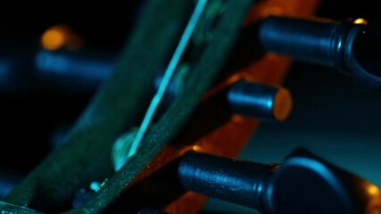 A cinematic rack focus travels down the strings of a traditional ethnic lute, possibly an Oud. Moody blue and orange lights create a mysterious, artistic closeup. - Powered by Adobe