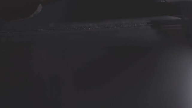 A close-up, low-angle shot of a musician passionately playing a marimba or vibraphone with mallets in a dark, atmospheric setting. Ungraded LOG footage for color grading.