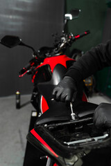 Motorcycle seat removal is essential for inspecting the electrical system. Technician carefully...