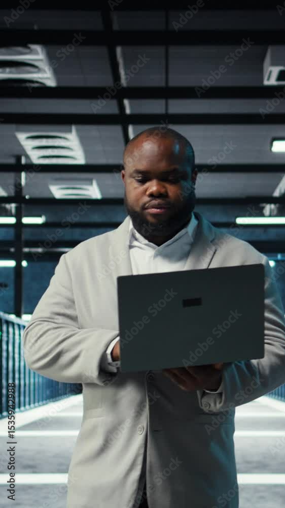 Poster vertical video data center computer scientist using laptop to manage system stability. server room i