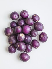 Purple potatoes scattered on a clean white background, small round shape with vibrant color