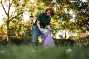 Young woman picking up trash in a public park