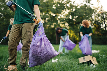 Group of volunteers picking up trash in park