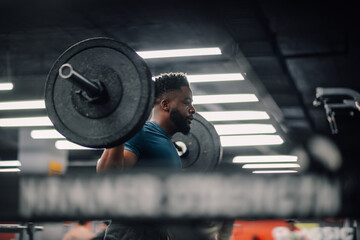 Determined athlete lifting weights in gym during intense workout