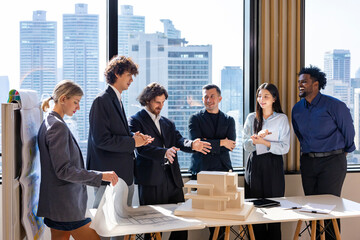 Team of diversity business people having agreement and handshake deal over new strategic strategy project on investment real estate with recognition and applause from other colleagues for partnership