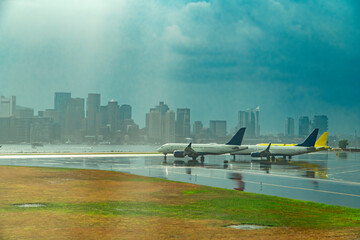 airplane in Boston airport and Boston skyline in the rain