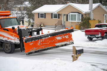 close up on snowplow driving on residential street