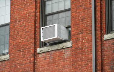 old air conditioner installed on rustic house window