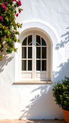 Classic arched window on textured white stucco wall, Mediterranean style