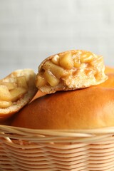Tasty baked patties in wicker basket on blurred background, closeup