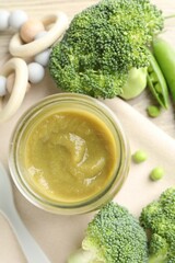 Baby food. Tasty puree in glass jar, ingredients and teether on table, flat lay