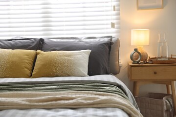 Comfortable bed with soft linens and blankets in room, closeup. Home textile