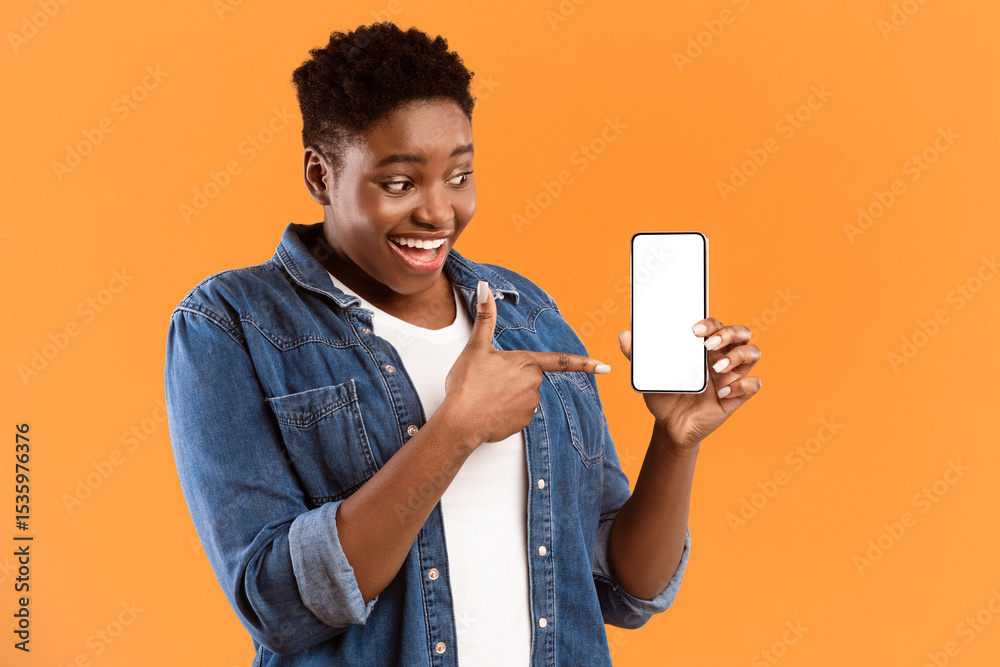Poster Cheerful Black Lady Showing Smartphone Blank Screen Recommending Application Posing Standing Over Yellow Studio Background. Mobile Application Ad. Check This App Concept. Mockup