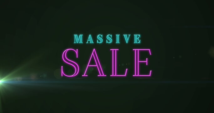 Glowing neon MASSIVE SALE text shining on dark electronic display, with greenish lens flare effect