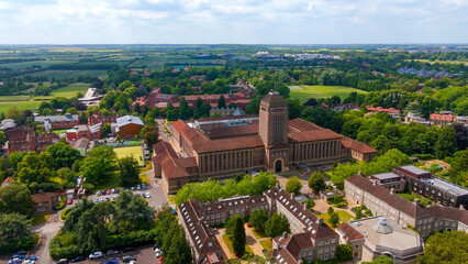 Aerial view of Cambridge University Library and surrounding buildings, showcasing the historic architecture and green campus on a bright summer day in England