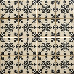 A patterned ceramic tile wall featuring black floral and geometric motifs on a beige background arranged in a grid.