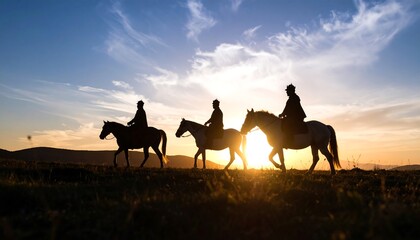Silhouettes of horsemen at sunset