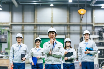 工場の中で考える作業員リーダー