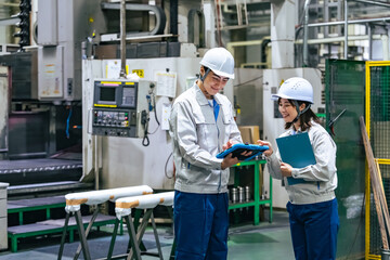 工場でタブレットを使って作業する作業員グループ