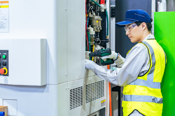 工場で工作機械のメンテナンスをする作業員